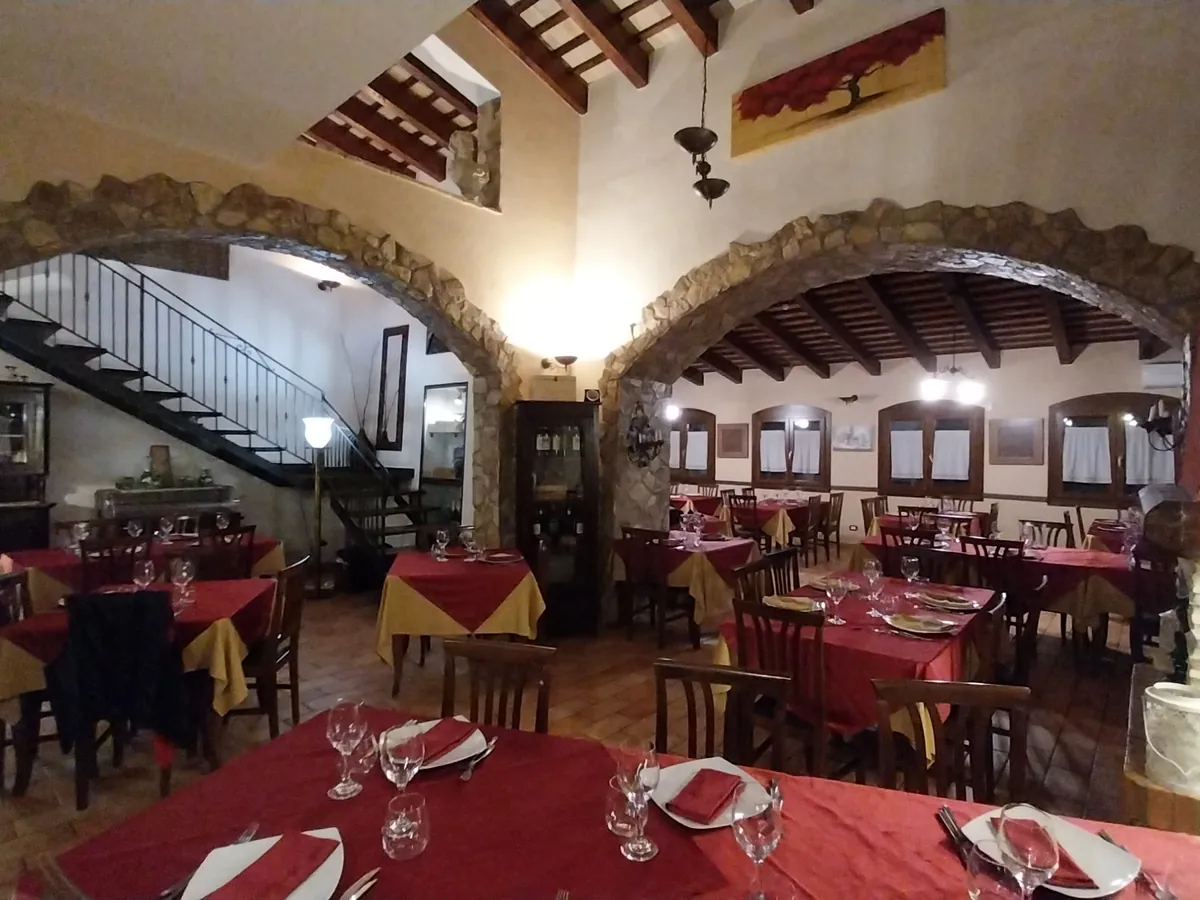 Sala con doppio arco in pietra e scala in ferro battuto