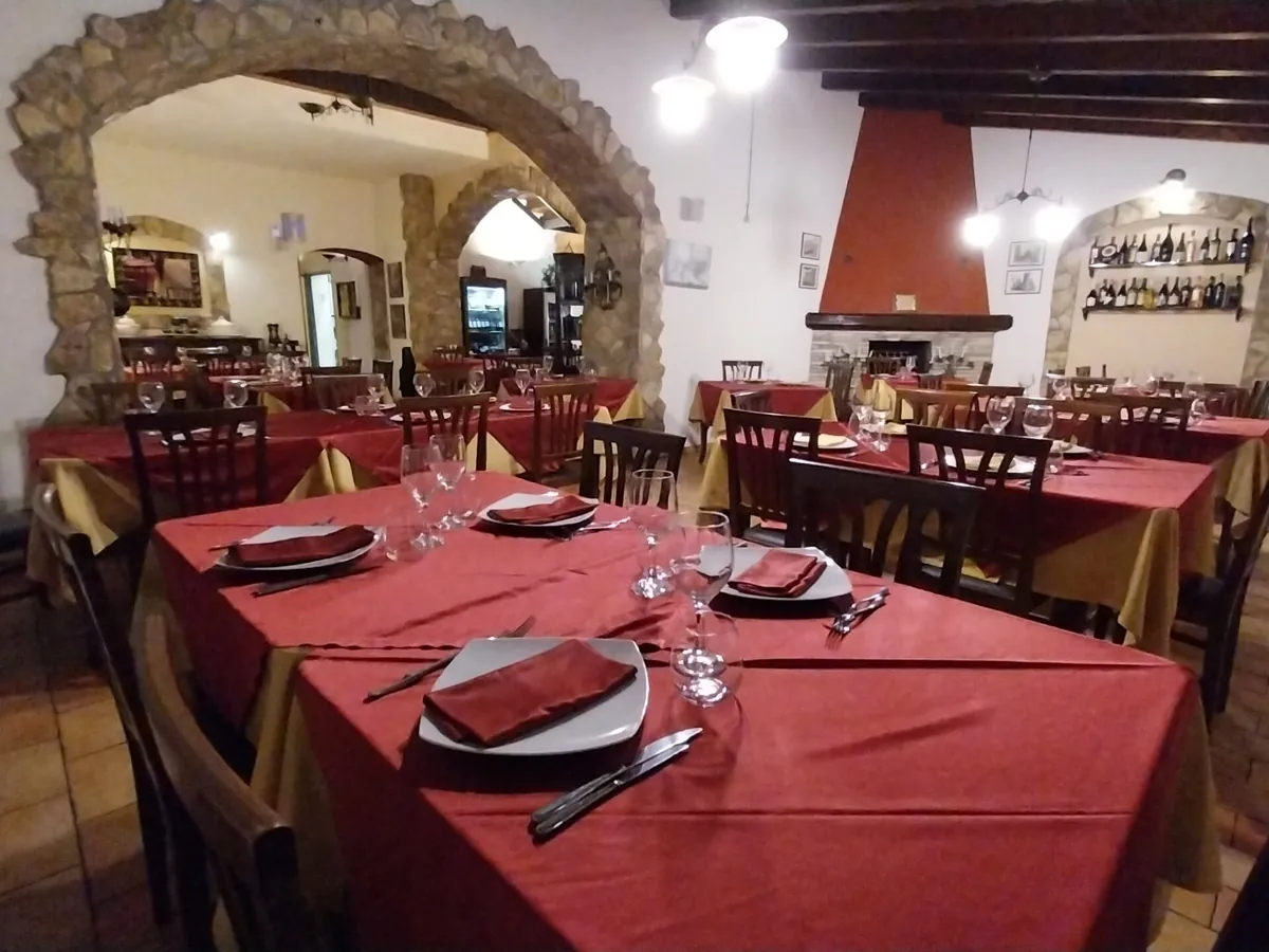 Sala principale con arco in pietra e camino
