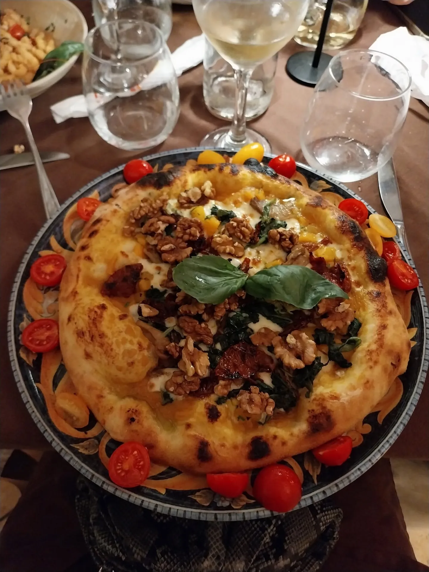 Pizza gastronomica con noci, basilico e pomodorini